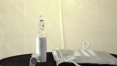 Siyah dönen masada şırınga, tıbbi maske ve aşı var..