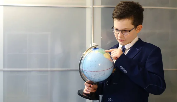 Elinde küreyle gözlüklü öğrenci, dünya yüzeyine bak..