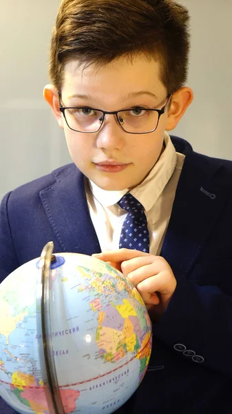 Elinde küreyle gözlüklü bir öğrenci..