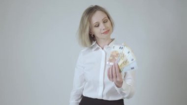 Beyazlı iş kadını kredi kartıyla para arasında seçim yapıyor. Beyaz arkaplanda 4K video görüntüsü izole edildi. Banka kartı ve nakit para seçimi.