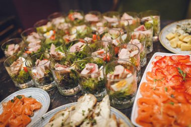 Restoranda cam bardaklar, tabaklar et ve balık aperatifleri. Kırmızı balıklı çerez, peynir, kızarmış ekmek