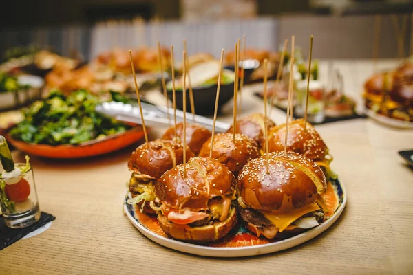 Arkaplanda yemek çubukları ve atıştırmalıklarla dolu yedi sulu altın hamburger tabağı. Restoranda yemek servisi yaptım. Hamburgerlere odaklandım. Gerçek servis yemekleri atmosferi.