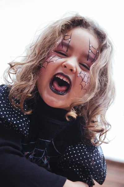 Little girl with painted spider web on face — Stock Photo, Image