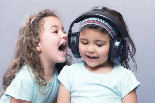 Older sister screaming at her younger sister in headphones — Stock Photo, Image