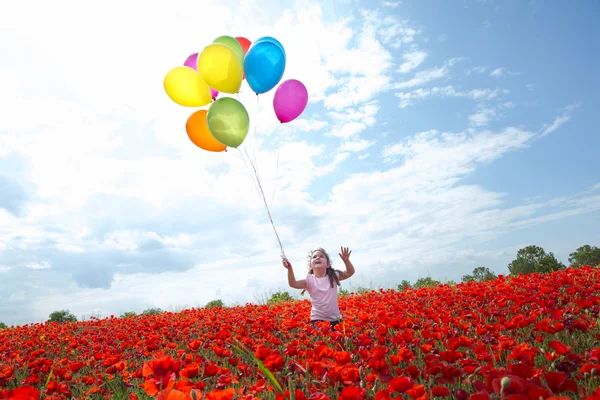Κοριτσάκι με πολύχρωμα μπαλόνια που φέρουν στο γαλάζιο ηλιόλουστο ουρανό — Φωτογραφία Αρχείου