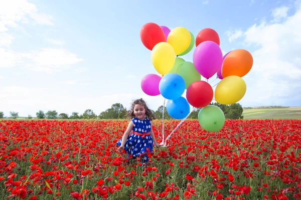 Χαριτωμένο χαμογελαστό κορίτσι με φωτεινά μπαλόνια σε κόκκινο φόντο — Φωτογραφία Αρχείου