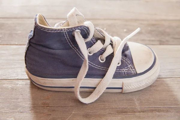 Obrázek dětské boty na dřevěnou podlahu — Stock fotografie