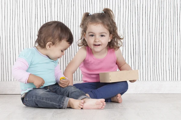 Zwei kleine Schwester spielen mit ein paar Tasten — Stockfoto