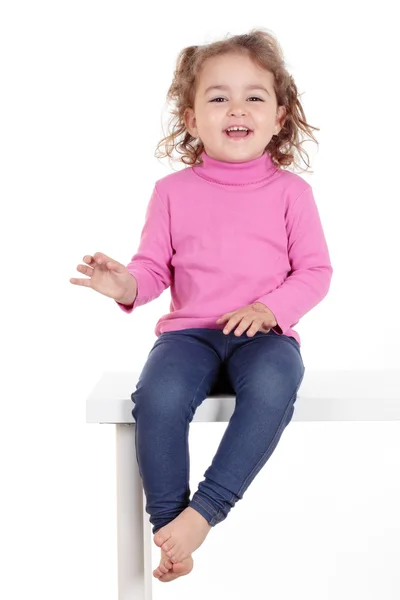 Beautiful smiling girl sits at a table — Stock Photo, Image