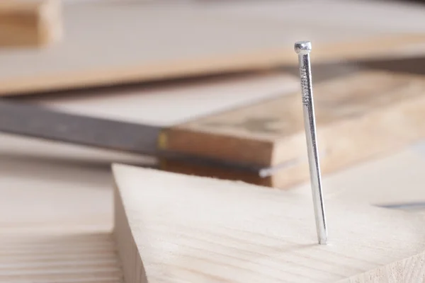 Close-up of nail hammered in wooden board — Stock Photo, Image