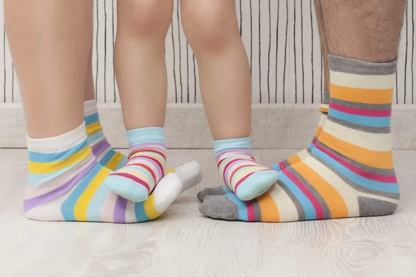 Mother, father and child wearing similar striped socks. Unrecognizable — Stock Photo, Image