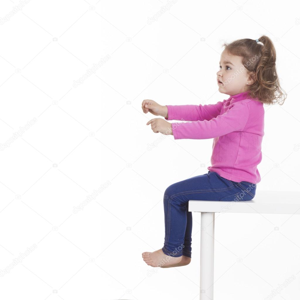 Ребенок сидит на стуле на белом фоне