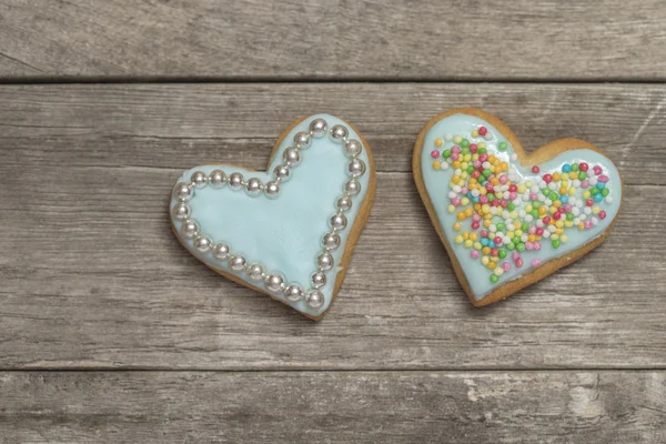 Zwei gebackene Herzen mit blauem Zuckerguss bedeckt — Stockfoto