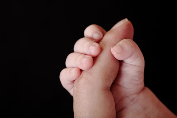 Baby holding adult person's finger — Stock Photo, Image