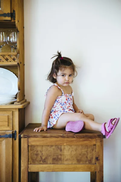 Petite fille mignonne avec queue assise sur une table en bois — Photo