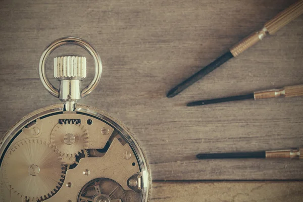 Nahaufnahme einer Taschenuhr mit Uhrwerk und Schraubendreher — Stockfoto