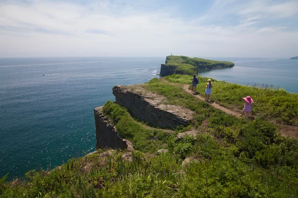 Mother with her daughters walking near sea — Stock Photo, Image