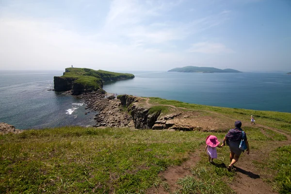 Mother with her daughters walking near sea — Stock Photo, Image