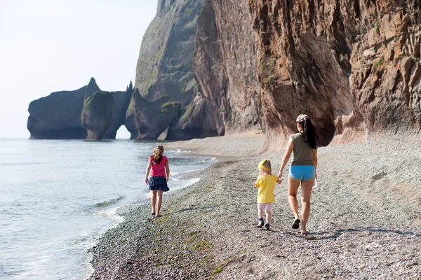 Mother and her daughters walking at the sea — Stock Photo, Image