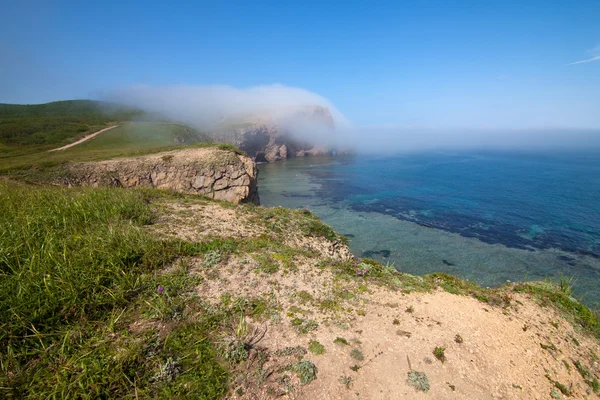 Nebel bewegt sich vom Meer auf einen Felsen zu — Stockfoto