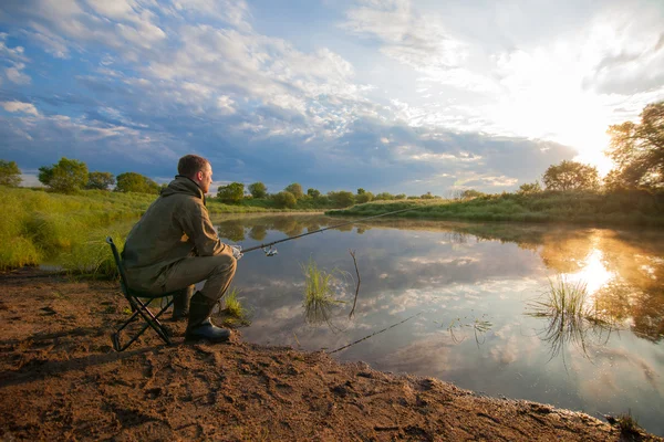 Fiskare med fisk-stav i hans händer nära en damm — Stockfoto
