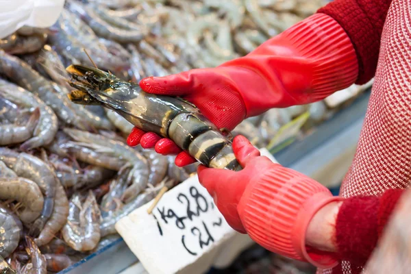 売り手は、魚市場で巨大な海老を保持しています。 — ストック写真