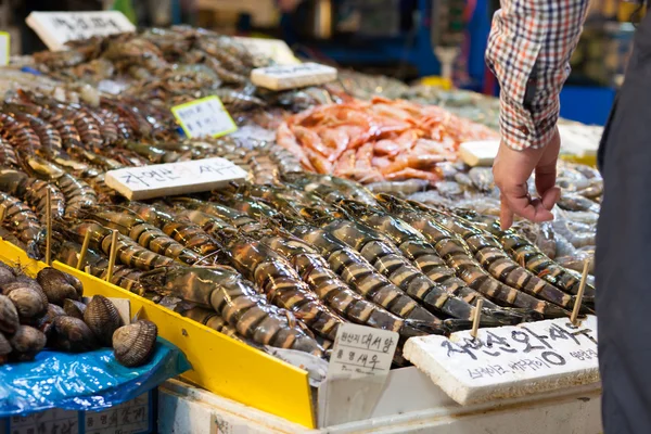 Man buying giant shrimps at fish market — Stock Photo, Image