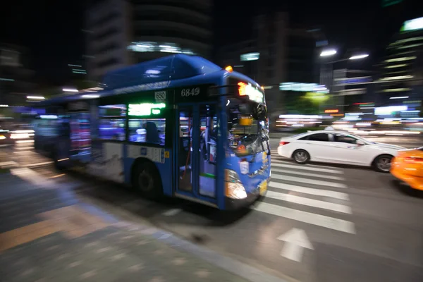 Autobús de la ciudad movimiento borroso en la noche — Foto de Stock