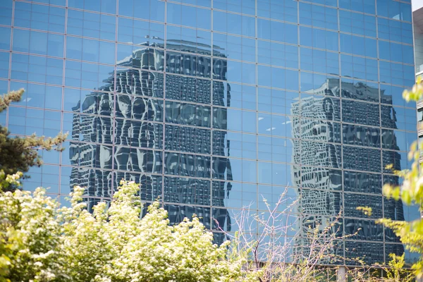 Edificios de oficinas reflejados en la pared de cristal de otro edificio —  Fotos de Stock