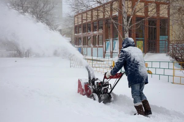 Chabarovsk, Rusko - 03 prosinec 2015: Muž, odklízení sněhu s — Stock fotografie