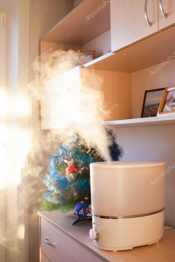 Humidifier spreading steam in morning light near artificial chri