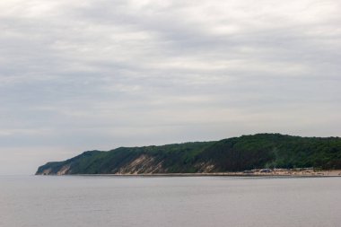 Gri bulutlu bir havada yarı ada denize düşüyor.