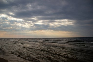 Gün batımında, ağır bulutların arasından gün ışığı.