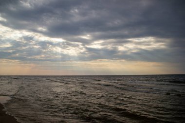 Gün batımında, ağır bulutların arasından gün ışığı.
