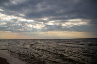 Gün batımında, ağır bulutların arasından gün ışığı.