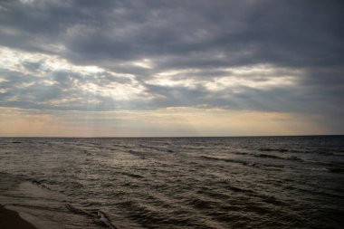 Gün batımında, ağır bulutların arasından gün ışığı.