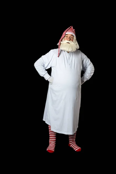 Noel Baba gecelikli ve gece içkisi giymiş elleri kalçasında dikkatle dinliyor. Siyah bir arkaplanda.