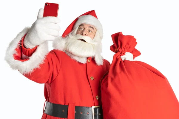 Noel Baba, izole edilmiş beyaz bir arka planda hediyelerle selfie çeker. Noel gençlik tasarımı.