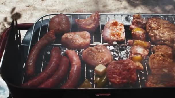 Gegrilde vlees met worstjes op de grill heerlijke steak close-up. Heet sappige boterachtige steak wordt gekookt in slow motion Videoclip