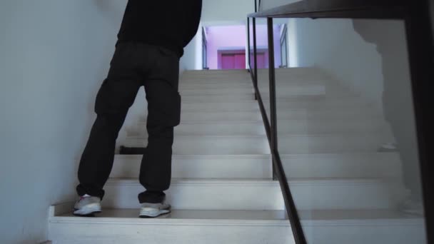 Sprzątanie schodów mopem. Widok z tyłu na męskiego sprzątacza czyszczącego podłogę schodów w pustym domu Klip Wideo