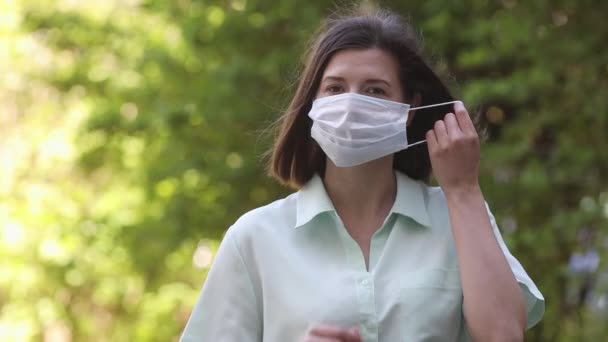 Молода красива жінка знімає медичну маску з обличчя . — стокове відео