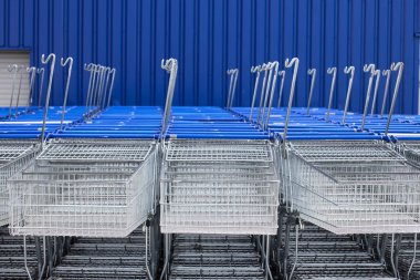 Süpermarkette alışveriş yapmak için bir sürü boş mavi metal araba. Koronavirüs salgını nedeniyle mağaza kapatıldı