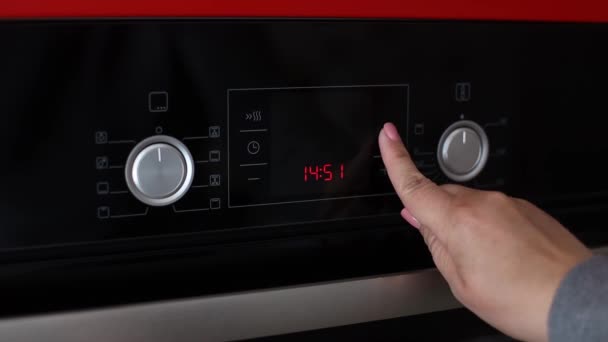 Vrouw hand indrukken beveiligingssleutel knop van kinderen op de elektrische oven console — Stockvideo