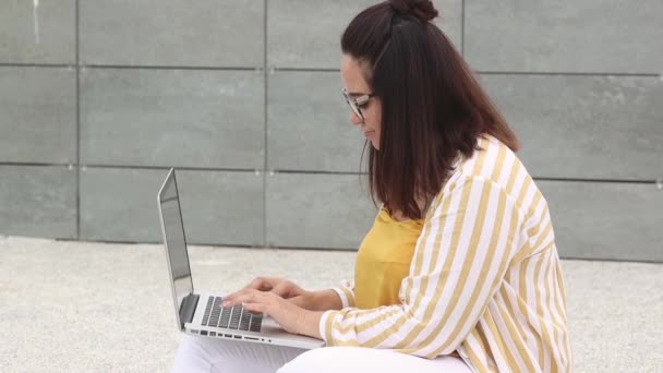 Портрет счастливой женщины plus size 30-35 лет, работающей на ноутбуке — стоковое видео