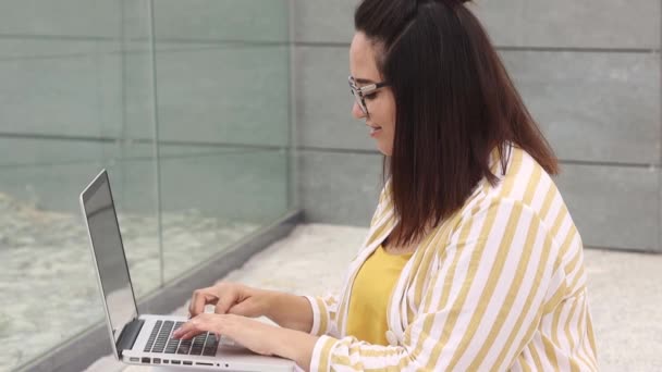 Портрет счастливой женщины plus size 30-35 лет, работающей на ноутбуке — стоковое видео