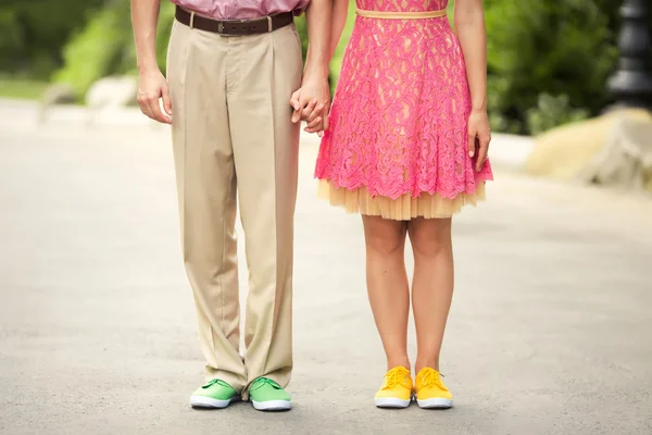 Paar Füße mit farbigen Turnschuhen — Stockfoto