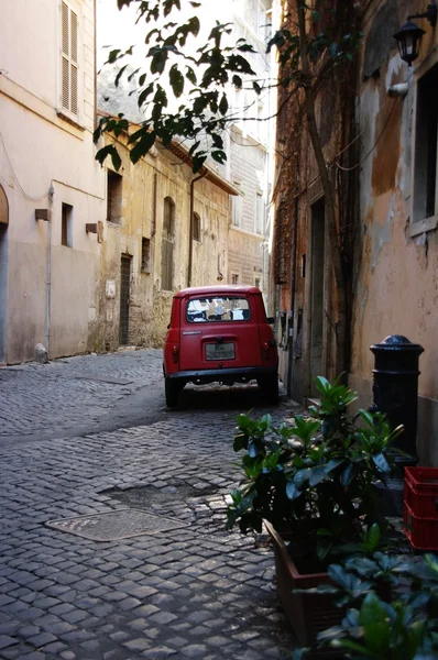 The narrow romantic Roman street and the old red car — Stock Photo, Image