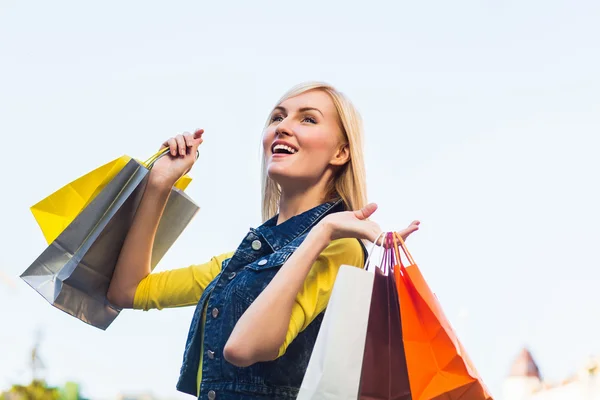 Venta, compras, turismo y gente feliz concepto - hermosa mujer con bolsas de compras en el ctiy — Foto de Stock