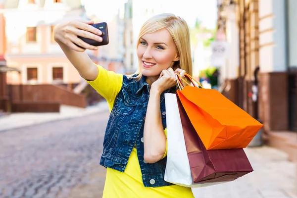 Mulher de compras com sacos falando no telefone ao ar livre — Fotografia de Stock