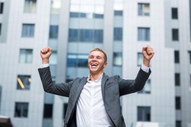 Mutlu genç iş adamı formal giyim kaldırdı ve açık havada duran ise pozitif ifade silah tutmak en iyi gün hiç tam uzunluğu